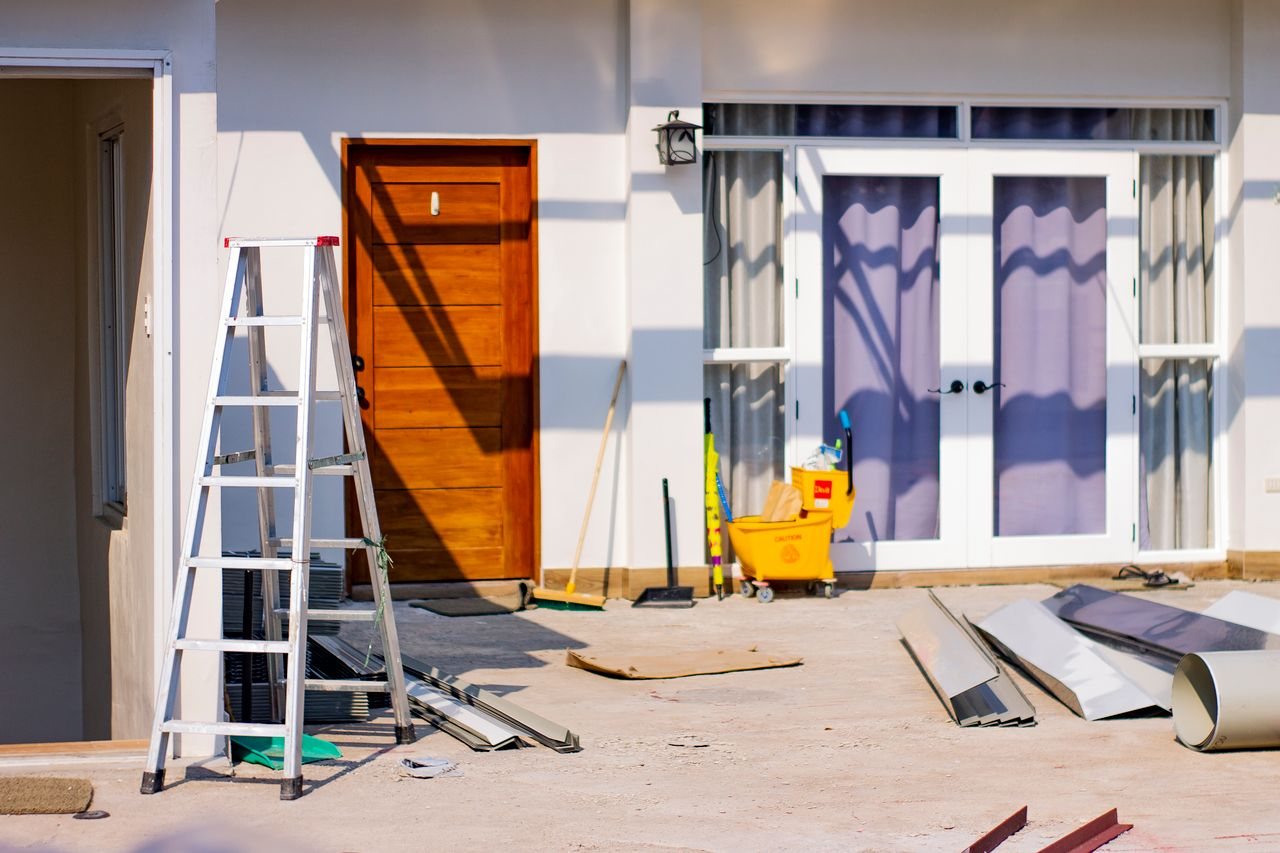 Free Front entrance of a house under renovation with tools and materials scattered around. Stock Photo